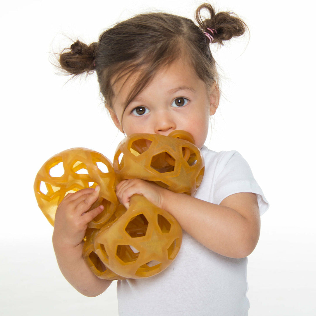 Child holding a bunch of rubber star balls